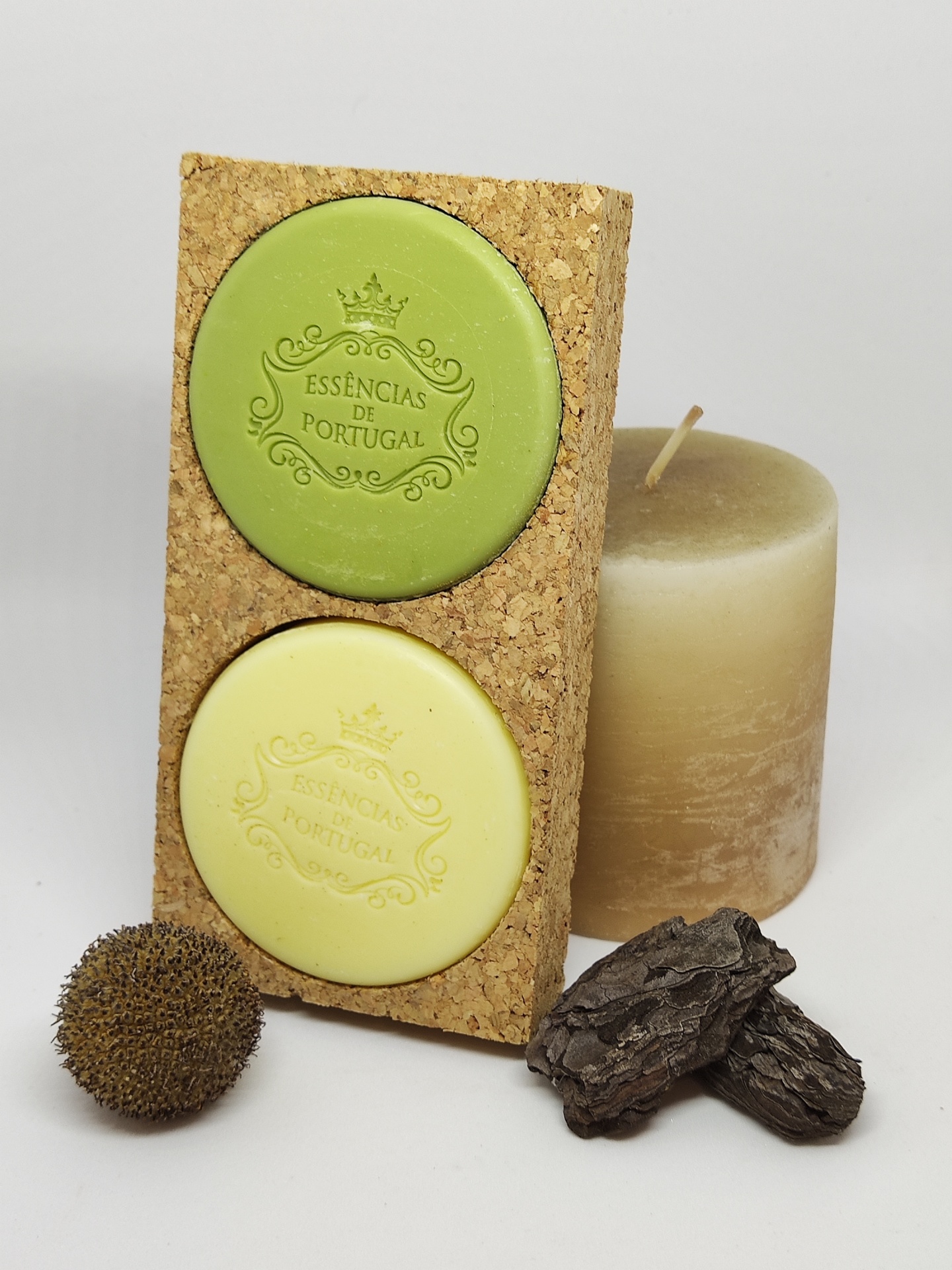 Aromatizadores redondos verde e amarelo em base de cortiça com vela, semente e pedaços de madeira