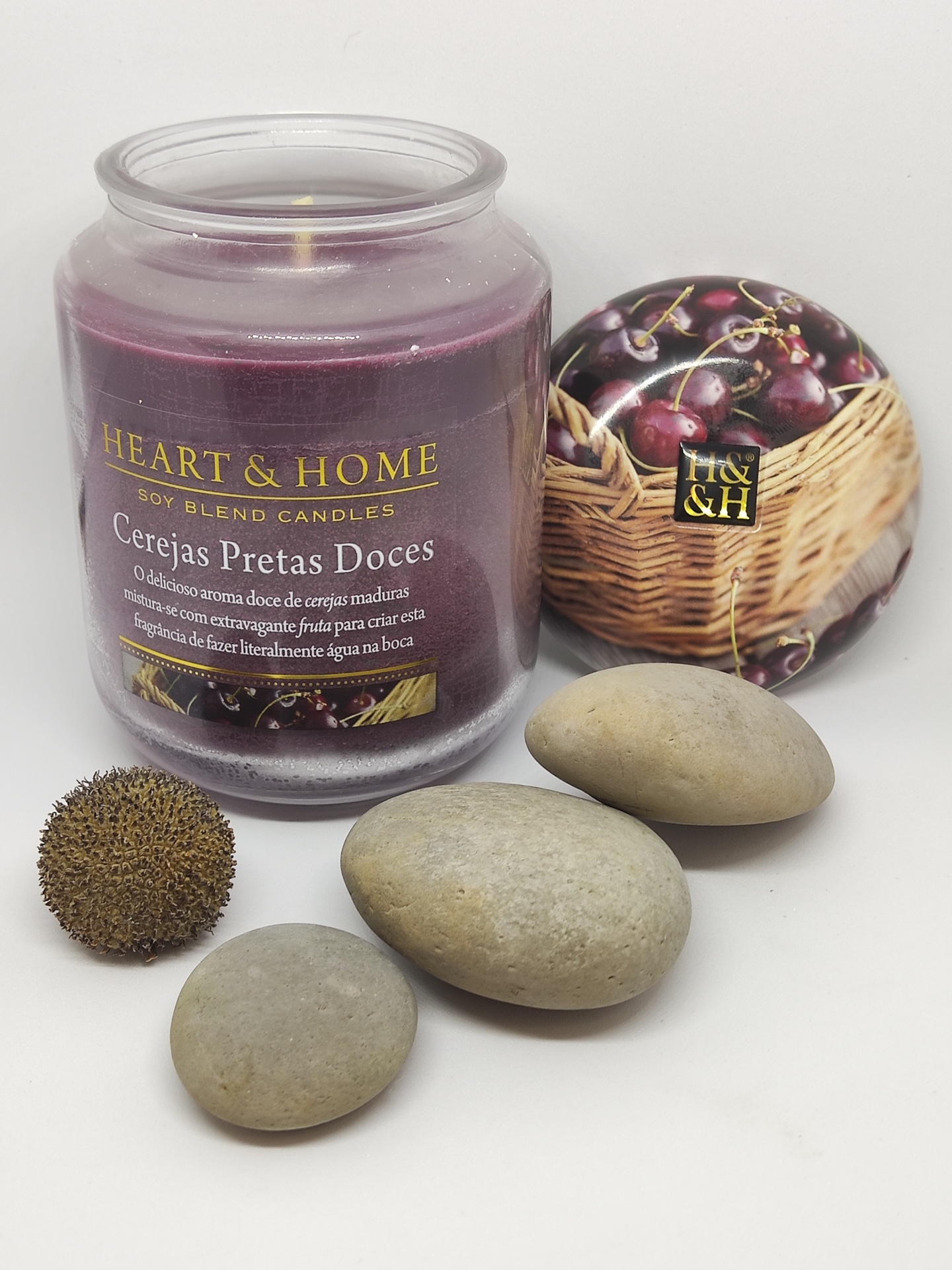 Vela aromática Heart & Home Cerejas Pretas Doces com pedras arredondadas ao lado