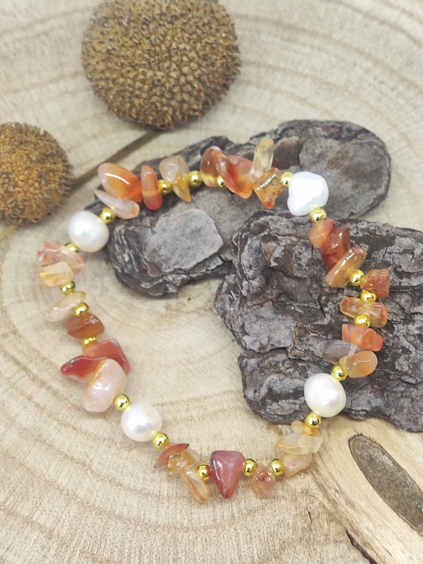 Pulseira colorida com pedras e pérolas sobre madeira