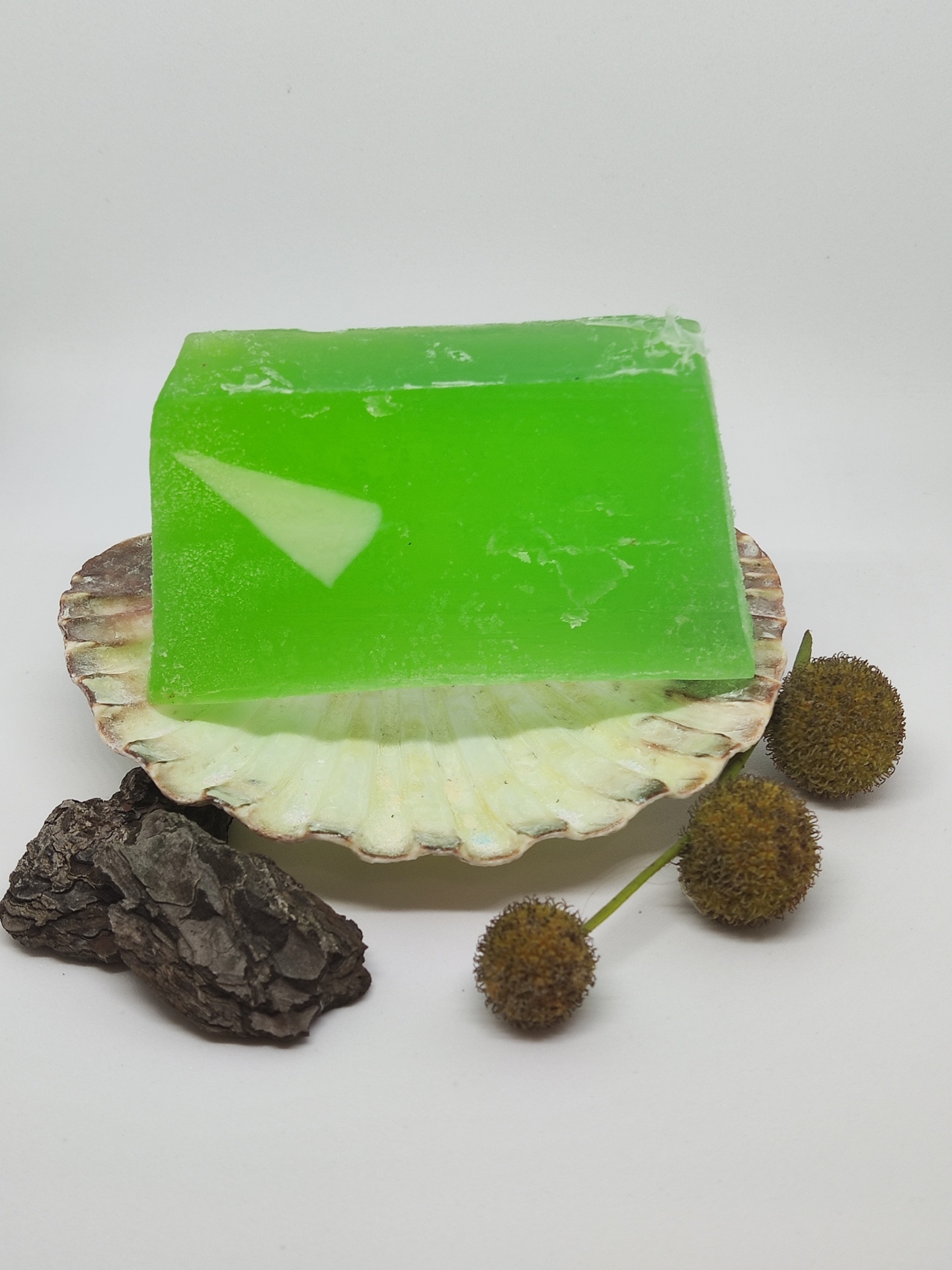 Sabonete verde numa concha com casca e frutos secos