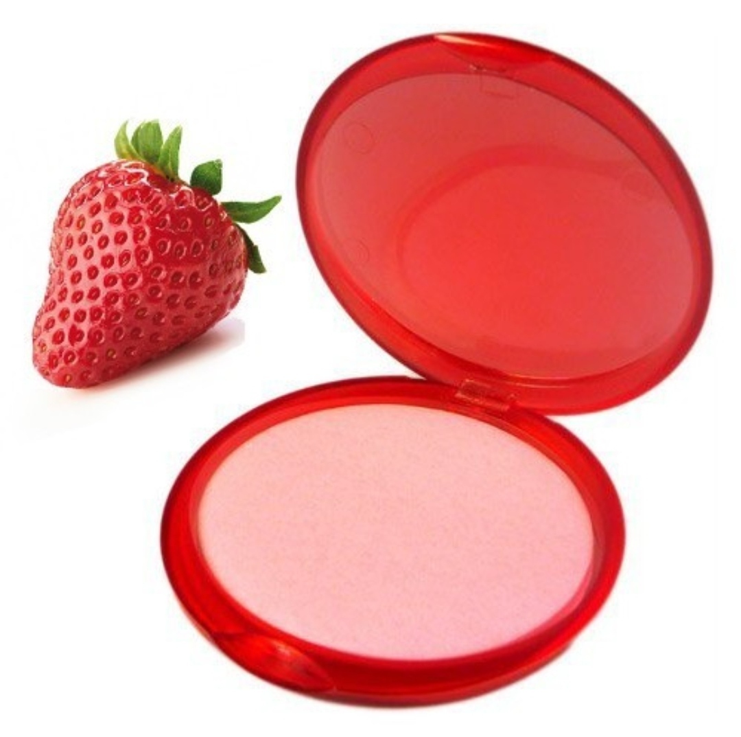 Estojo de maquilhagem vermelho aberto com pó cor-de-rosa ao lado de um morango