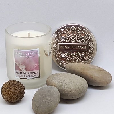 Vela perfumada com etiqueta e pedras em fundo branco