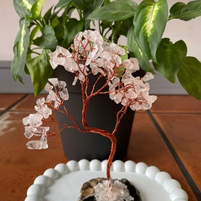 Árvore decorativa de arame e cristais com base de geodo num prato branco em mesa de azulejos