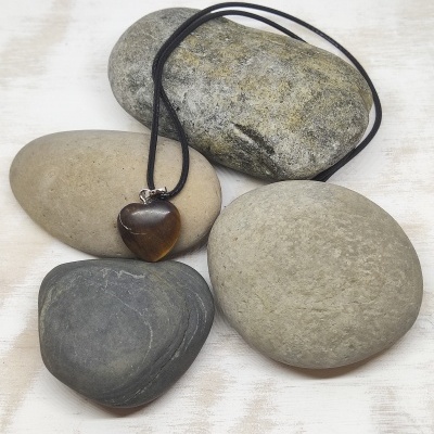 Colar com pendente castanho coração sobre pedras cinzentas
