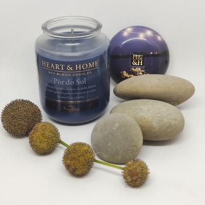 Vela azul em frasco de vidro com pedras e flores secas