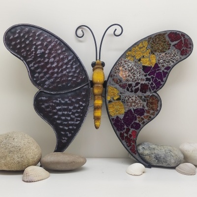 Escultura decorativa de borboleta com asas coloridas em mosaico