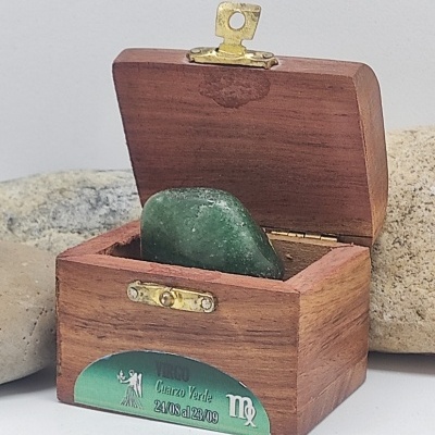 Caixa de madeira com pedra verde e etiqueta com texto Cuarzo Verde e datas