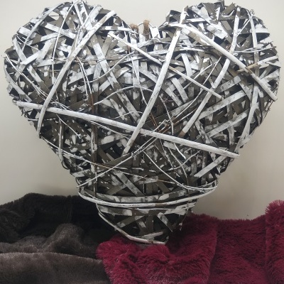 Coração decorativo feito de ramos entrelaçados sobre tecidos macios