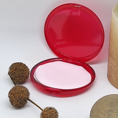 Espelho compacto redondo vermelho com frutos secos, vela e pedra