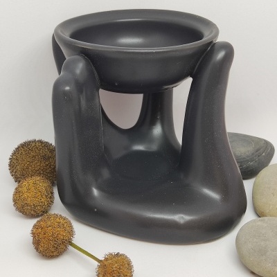 Aromatizador em forma de mão com pedras e flores secas ao lado