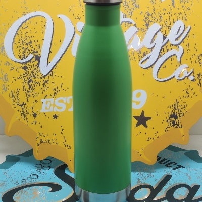 Garrafa térmica verde com tampa e base em aço inoxidável diante de fundo decorativo amarelo e azul