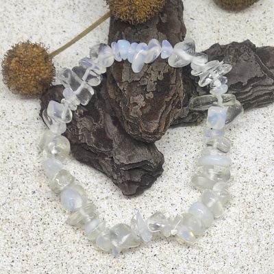 Pulseira de pedras iridescentes brancas e translúcidas sobre casca e fundo claro