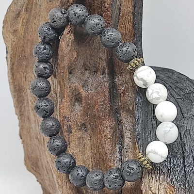 Pulseira de bolas pretas e brancas sobre madeira rústica