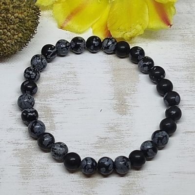 Pulseira de contas pretas e cinza com padrão de manchas brancas