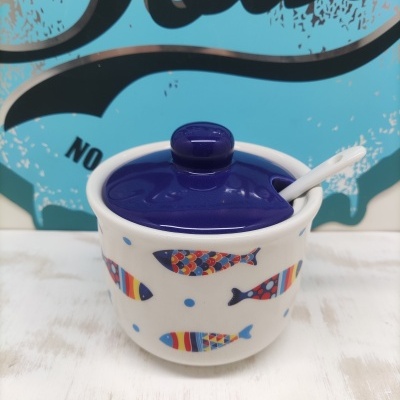 Pote cerâmico com tampa azul e decoração de peixes coloridos.