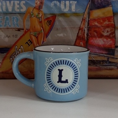 Caneca azul clara com letra L e padrão circular decorativo