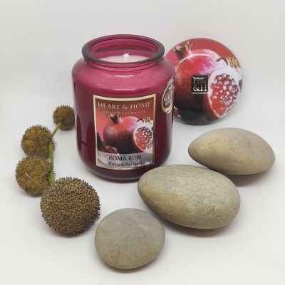 Vela vermelha em frasco de vidro com flor seca, pedras e caixa redonda decorada com romã.