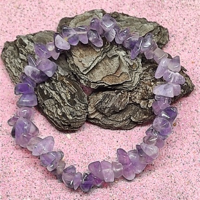 Pulseira de pedras roxas em casca sobre fundo rosa