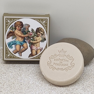 Sabonete redondo bege com embalagem decorada com anjos e texto essências de Portugal.