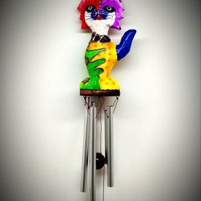 Sino dos ventos colorido em forma de gato pendurado numa parede branca