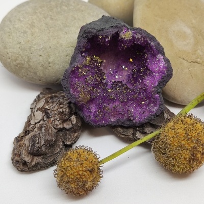 Pedras decorativas com geode roxa e esfera amarela sobre fundo branco