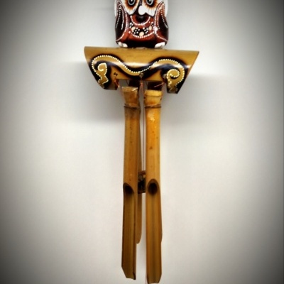 Móbile pendurado com cabeça de coruja e tubos de madeira clara