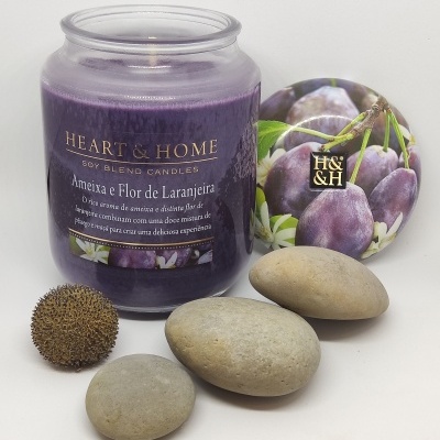 Vela aromática roxa em frasco de vidro com tampa decorativa e pedras cinzentas