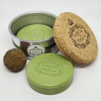 Sabonete verde redondo com selo, lata metálica aberta e tampa de cortiça com selo