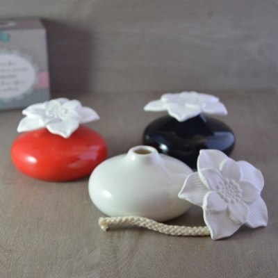 Difusores de cerâmica coloridos com flores brancas no topo