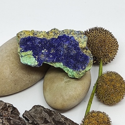 Pedras lisas, rocha com cores azul e verde, cascas de árvore e flores secas