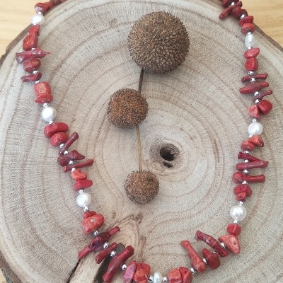 Colar colorido com pedras e pérolas sobre tábua de madeira redonda