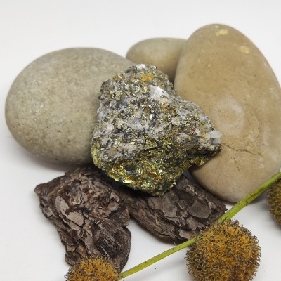 Três pedras lisas, pedra mineral com glitter, casca de árvore e flores secas sobre fundo branco