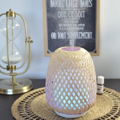 Difusor de aroma em tecido trançado com luz azul, relógio de areia dourado e texto em francês no quadro