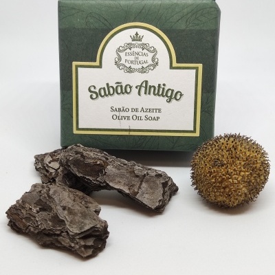 Sabonete Sabão Antigo embalado com casca de árvore e fruto seco ao lado.