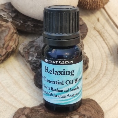 Frasco azul de óleo essencial Relaxing sobre madeira e cascas