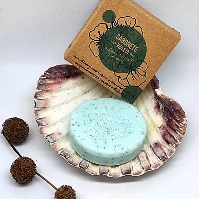 Sabonete azul claro em concha com embalagem de papel castanho e texto SABONETE VIOLETA