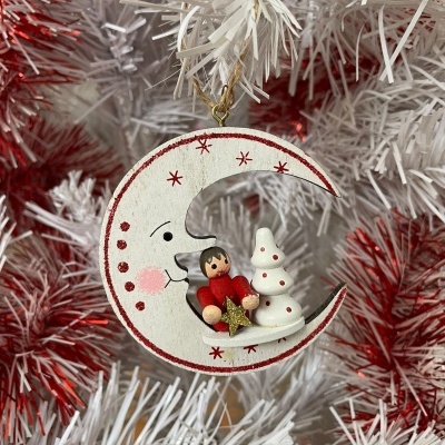Enfeite de Natal lua crescente com criança e árvore de Natal pendurado em árvore branca e vermelha