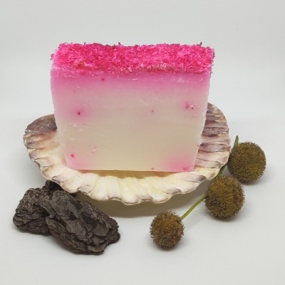 Sabonete rosa e branco decorado sobre concha com casca e flores secas