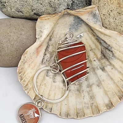 Chaveiro de pedra vermelha com arame e pendente Aries sobre concha