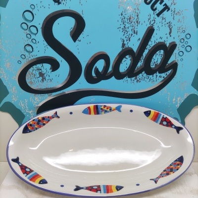 Prato oval branco com peixes coloridos e texto 'QUALITY PRODUCT Soda' no fundo azul