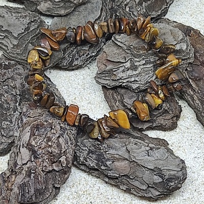 Pulseira de pedras castanhas e amarelas sobre casca de árvore