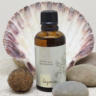 Frasco âmbar de essência para brumizador com concha e pedras em fundo de areia