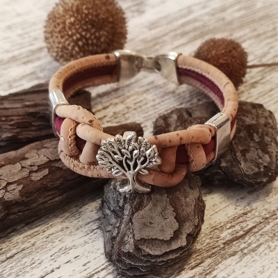Pulseira de cortiça com pendente de árvore e tecido bordeaux sobre madeira clara