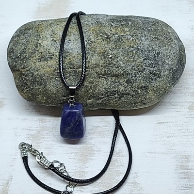 Colar com pendente de pedra azul sobre pedra cinzenta