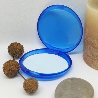 Espelho redondo azul com pedras, bolas secas e vela beige