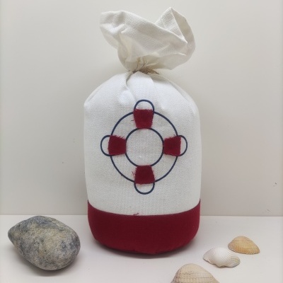 Saco branco e vermelho com desenho de bóia salva-vidas, conchas e pedra ao lado.