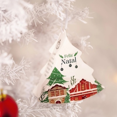 Enfeite de Natal em forma de árvore com desenho de casas e texto Feliz Natal