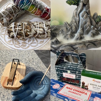 Produtos e suportes para queimar incenso, incluindo sálvia, montanha decorativa, mão azul e caixas de Nag Champa e Palo Santo.