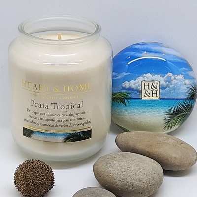 Vela branca em frasco de vidro com tampa decorativa e pedras ao redor