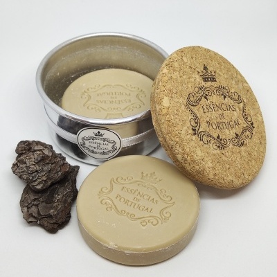 Sabonete redondo bege claro com gravura, tampa de cortiça e embalagem metálica prateada